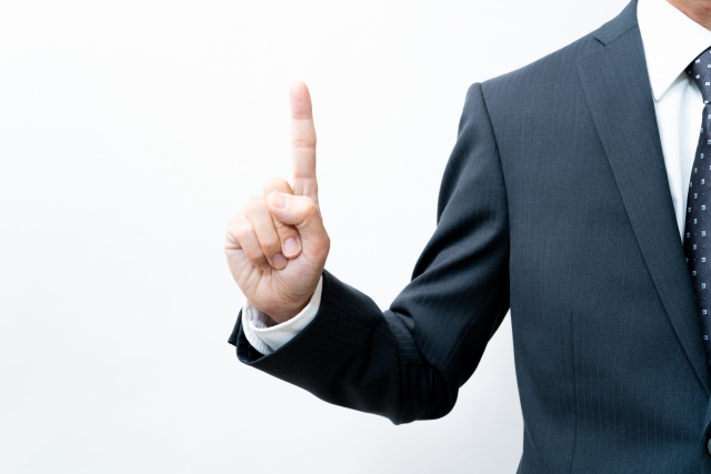 指をさすスーツの男性